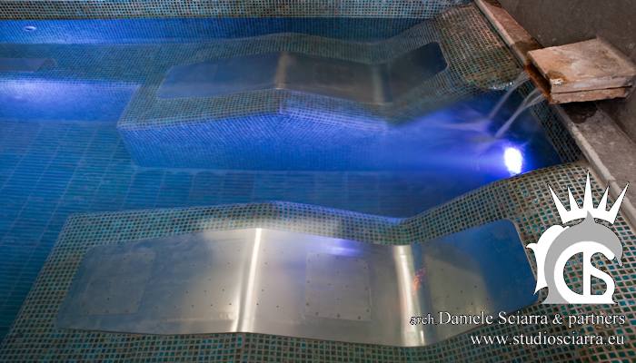 Piscina in mosaico con sedute e lettini idromassaggio